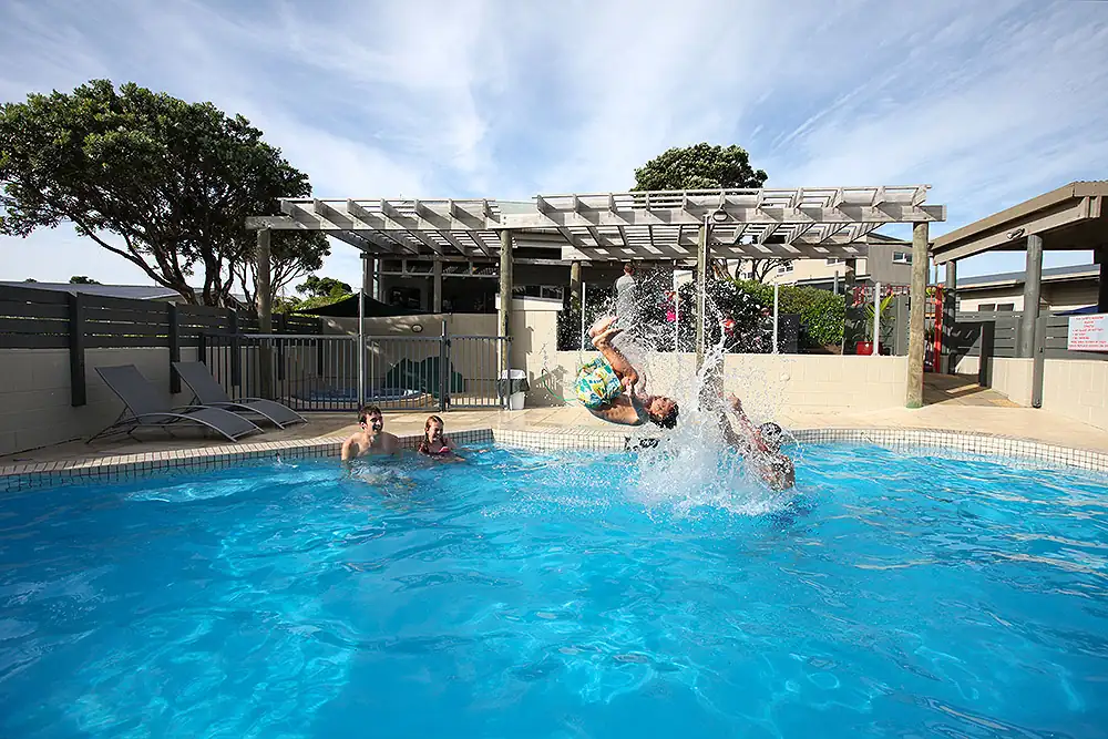 Kid doing back flip in pool at Pacific Rendezvous, fun with family 